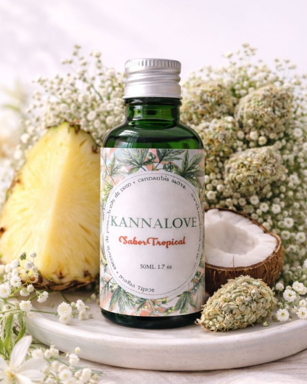 Aceite corporal de cannabis Sueño Tropical de Kannalove con piña, coco y flor de CBD, presentado en envase verde sobre fondo botánico.